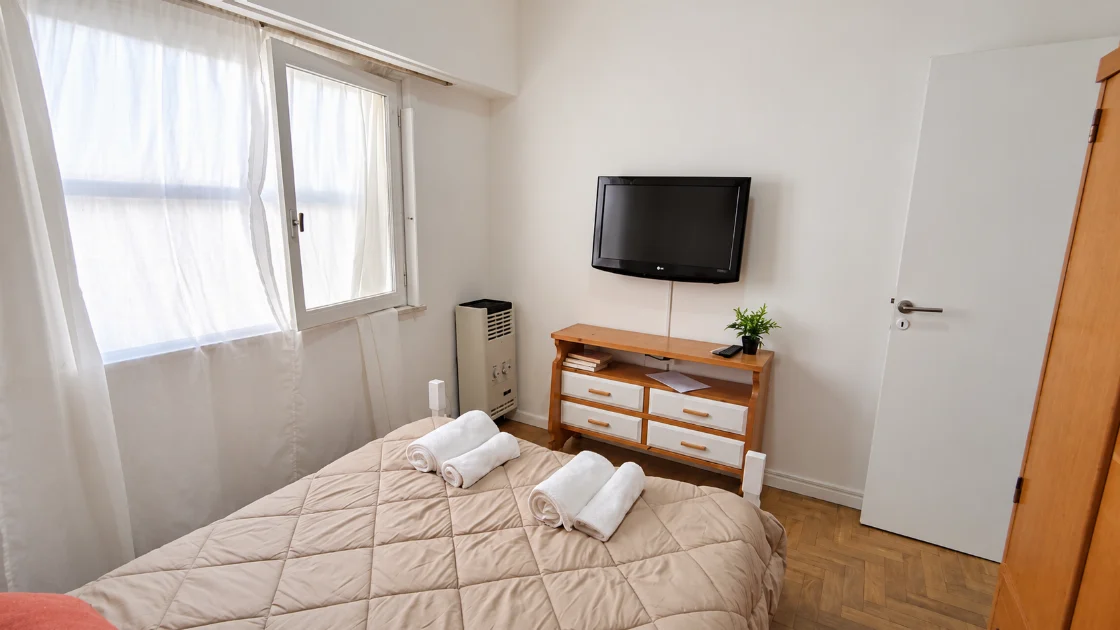 Otra perspectiva del dormitorio principal con cama grande y muebles de madera.